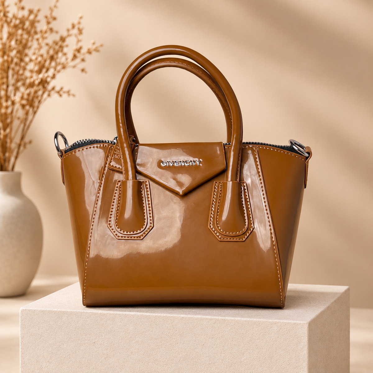 A05 caramel handbag on warm beige studio pedestal