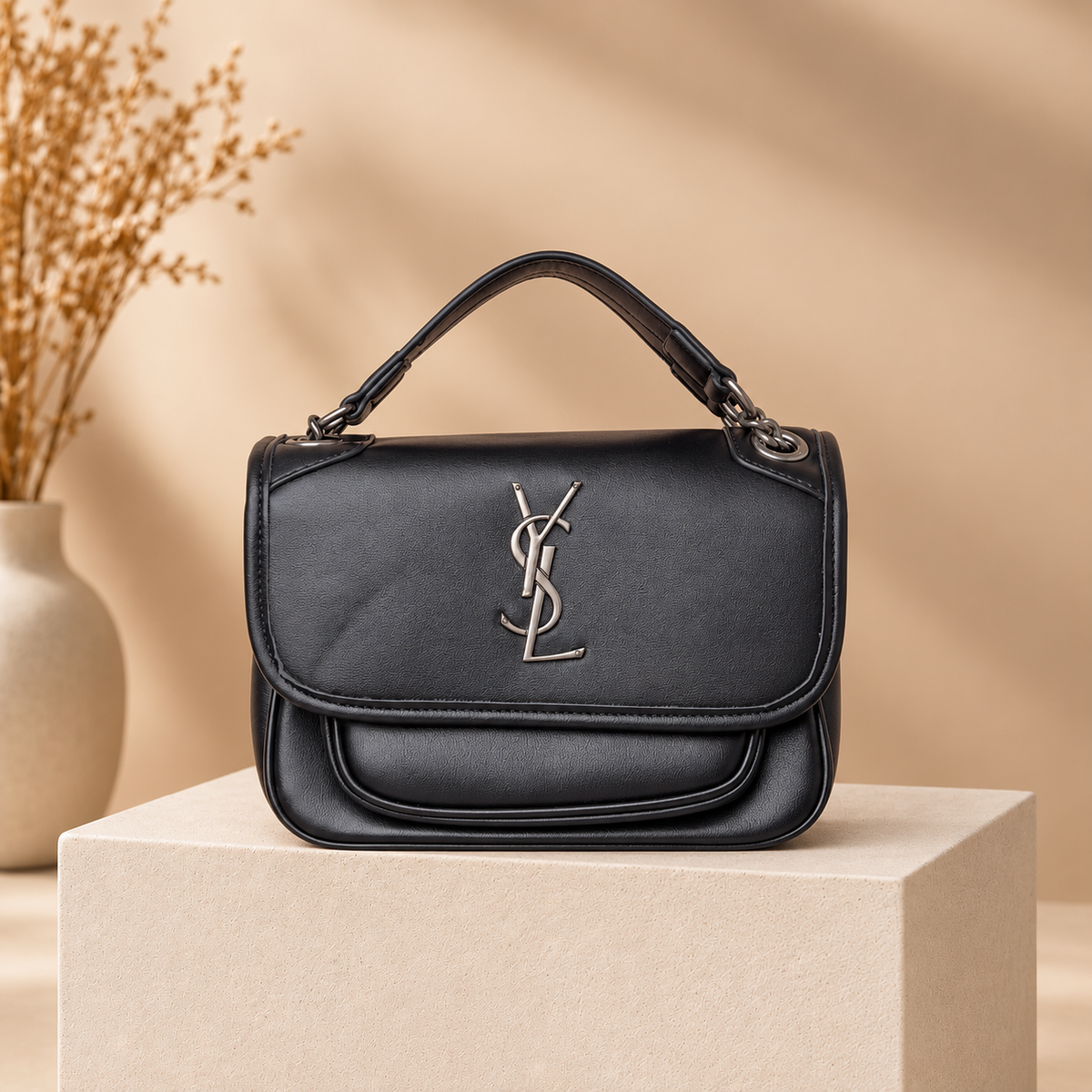 B01 black handbag on warm beige studio pedestal